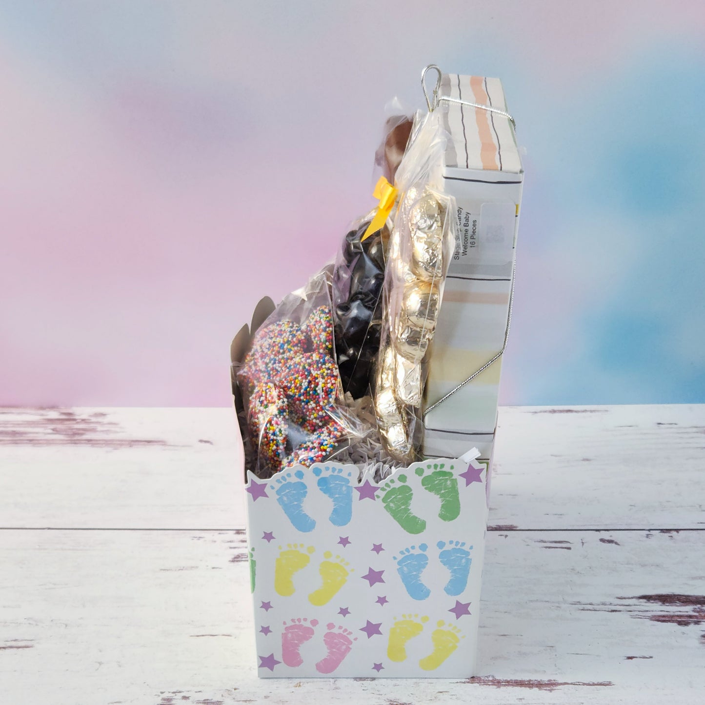 Inside our Baby Shower Gift Basket you will find a 16-piece chocolate assortment featuring creamy caramels, dreamy meltaways, rich truffles, and smooth creams in both milk and dark chocolate. We’ve also tucked in dark chocolate-covered cranberries, milk chocolate nonpareils, chocolate-covered Oreos, shiny foiled chocolate hearts, and the star of the show—a lovable milk chocolate teddy bear.