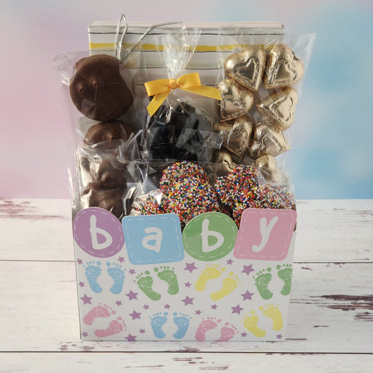 Inside our Baby Shower Gift Basket you will find a 16-piece chocolate assortment featuring creamy caramels, dreamy meltaways, rich truffles, and smooth creams in both milk and dark chocolate. We’ve also tucked in dark chocolate-covered cranberries, milk chocolate nonpareils, chocolate-covered Oreos, shiny foiled chocolate hearts, and the star of the show—a lovable milk chocolate teddy bear.