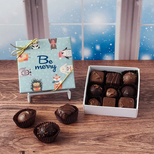 Box of chocolates with a decorative card on a wooden surface