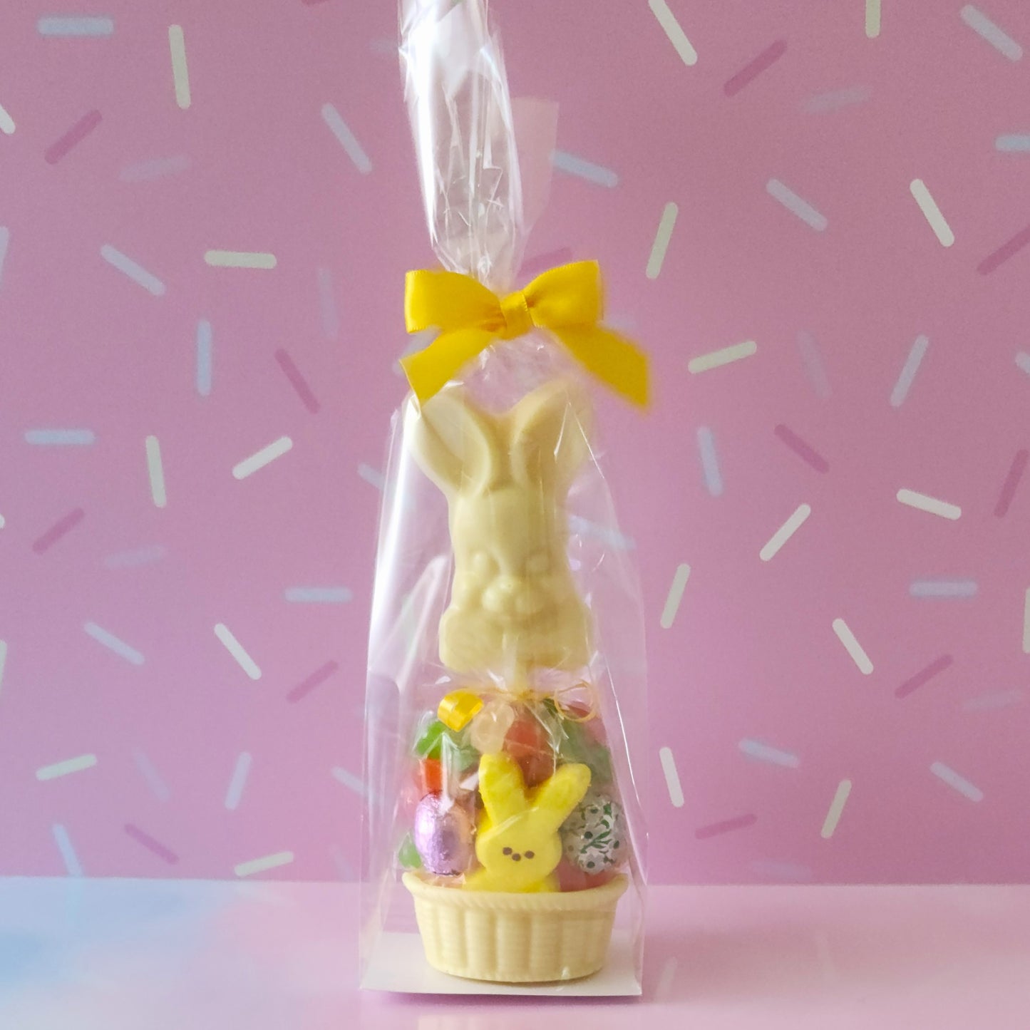 It starts with a white chocolate basket. We fill it with fruit flavored jelly beans, a soft marshmallow Peep, chocolate foiled eggs, and finish with a Bowtie Bunny Pop. This basket is a fun treat for Easter!
***Due to its fragile nature this item is only available for in-store pick-up. It can not be shipped***