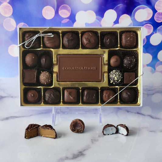 Celebrate their milestone with our 20-piece Congratulations Candy Box! Inside, a beautifully crafted milk chocolate card that says "Congratulations" is surrounded by an irresistible assortment of milk and dark chocolate soft center creams, rich caramels, and decadent truffles. This premium chocolate gift box is the perfect way to sweeten their success and share in their joy!