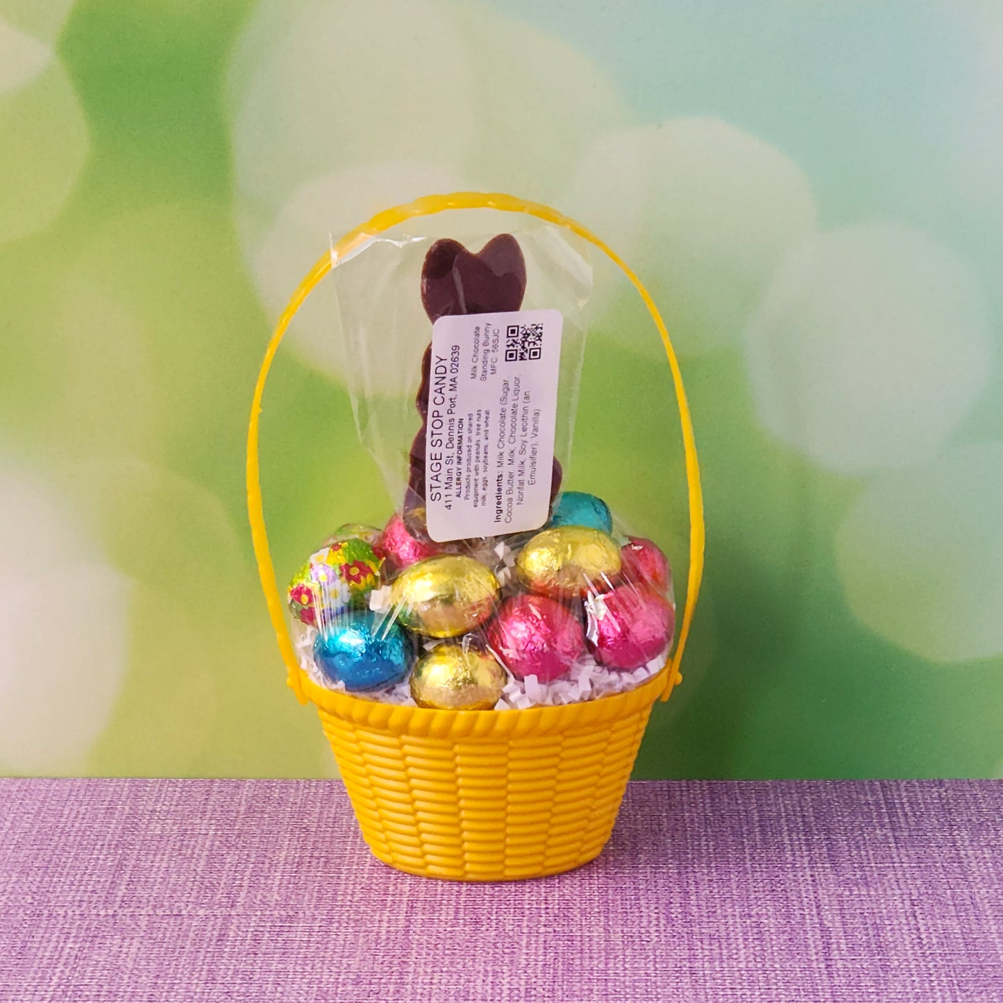 Yellow basket filled with foiled milk chocolate eggs and milk chocolate bunny pop