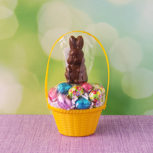 Yellow basket filled with foiled milk chocolate eggs and milk chocolate bunny pop
