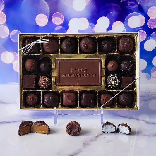 Commemorate your special day with our 20-piece Happy Anniversary Candy Box! Inside, a beautifully crafted milk chocolate card that says "Happy Anniversary" is surrounded by a delightful assortment of creamy milk and dark chocolate soft center creams, decadent truffles, and luscious caramels. It's the perfect way to celebrate your love and add a touch of sweetness to your anniversary!