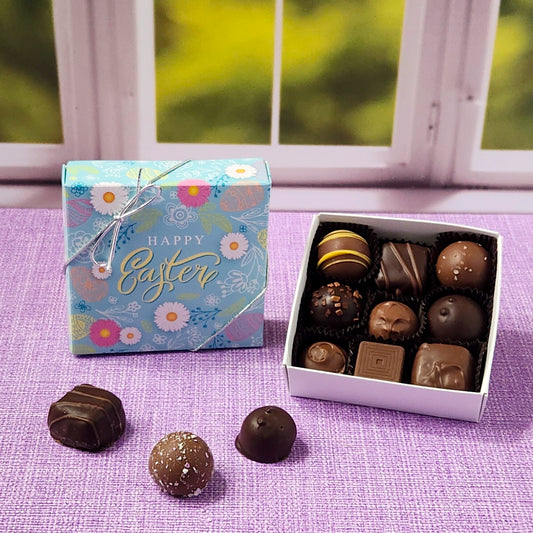 Box of chocolates with a 'Happy Easter' card on a purple surface