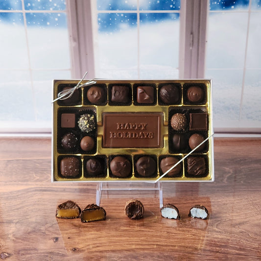 Make the season bright with our 20-piece Happy Holidays Candy Box! Inside, a beautifully crafted milk chocolate card that says "Happy Holidays" is surrounded by an irresistible assortment of smooth milk and dark chocolate soft center creams, decadent truffles, and rich caramels. It's the perfect way to share festive joy and delicious treats with loved ones!