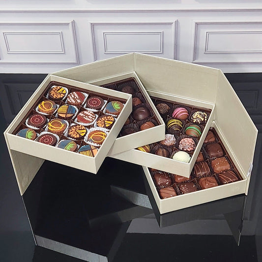 Hexagonal chocolate box with assorted chocolates on a dark surface.