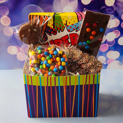A colorful and bold basket filled with all of your super heros favorite treats. Chocolate dipped oreos, M & M Pretzels, Milk Chocolate nonpareils and a chocolate fun bar. Also included is a 16 piece Milk and Dark Chocolate Assortment with creams, caramels, meltaways and truffles. The lid on the assortment says "Super" in a comic book style.