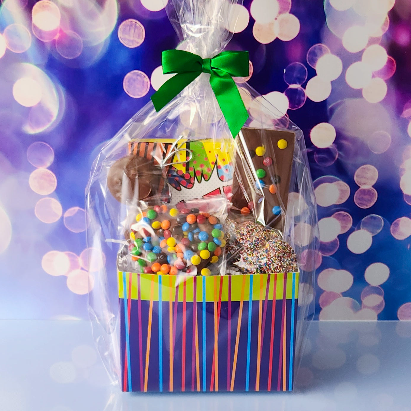 A super hero themed basket that comes with all your favorite chocolate treats. Milk Chocolate Oreos, M & M Pretzel, nonpareils, a chocolate fun bar and a 16 piece chocolate assortment. All overwrapped and tied with a bow making it ready to gift.