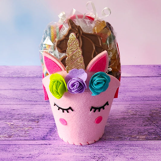 A gift basket filled with Milk Chocolate Unicorn, 12 flavored gummy bears, Salt Water Taffy, and Rainbow Sour Power Belts.
