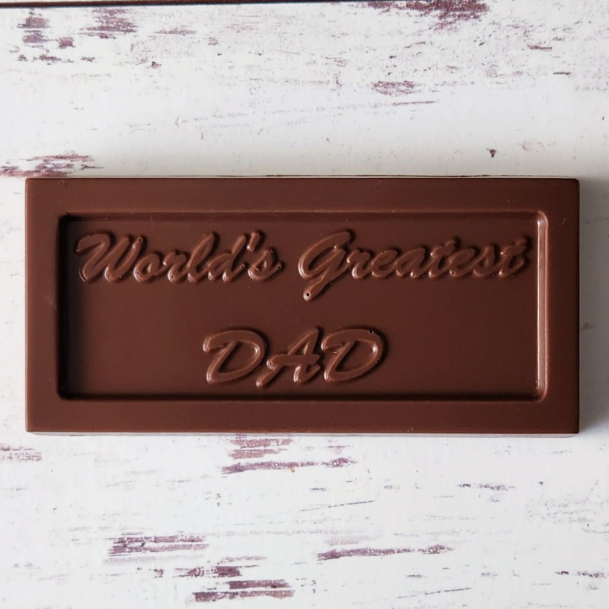 A solid milk chocolate candy bar with the words "World's Greatest Dad" imprinted on it. A perfect treat for Dad this Father's Day.