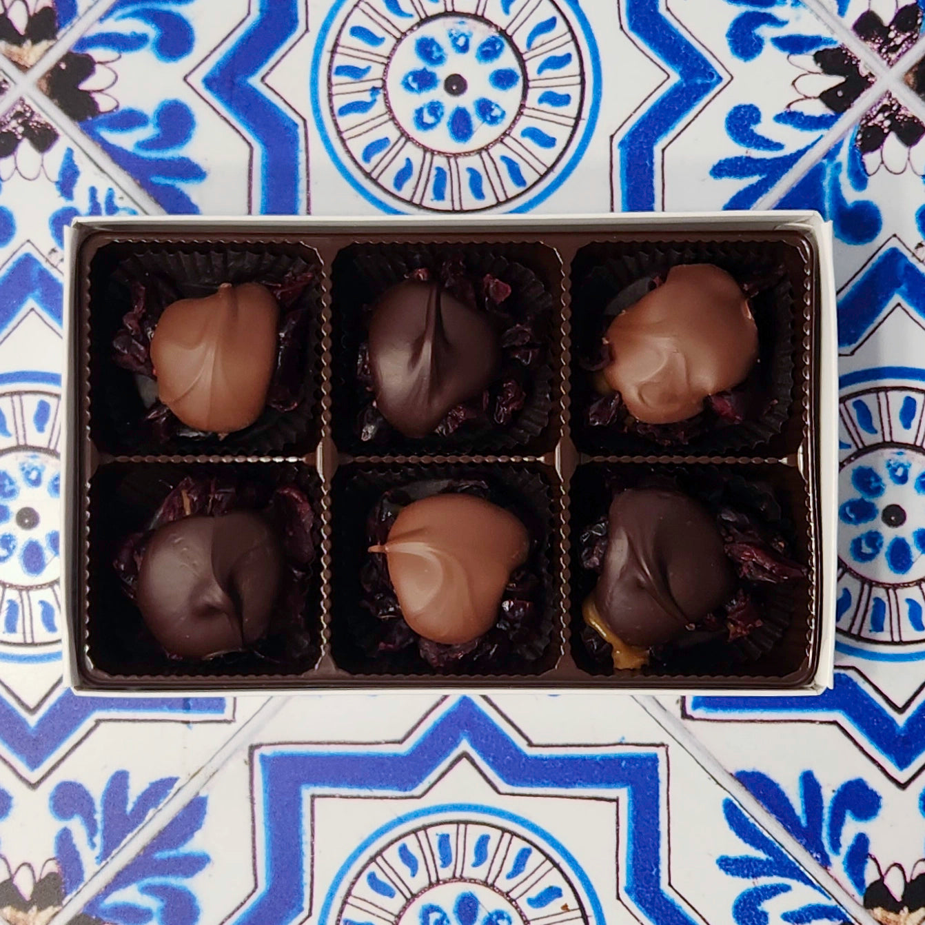 A seasonal favorite. Dried cranberries are surrounded by delicious caramel and topped with Milk chocolate or Dark chocolate. This 6 piece box features 3 Cranberry Caramel Clusters capped with Milk chocolate and 3 with Dark chocolate.