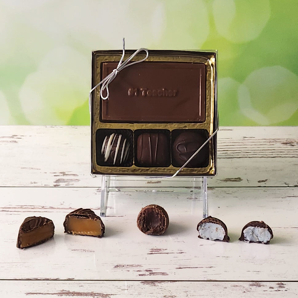 Celebrate your favorite teacher with our 3-piece #1 Teacher Candy Box! Inside, a beautifully crafted milk chocolate card that says "#1 Teacher" is paired with a smooth soft center cream, an indulgent truffle, and a delicious caramel. It's the perfect small gift to show your appreciation and brighten their day!