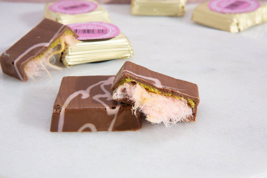 Chocolate candy bar with pink filling on a white surface