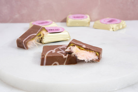 Chocolate bars with pink and white filling on a white surface
