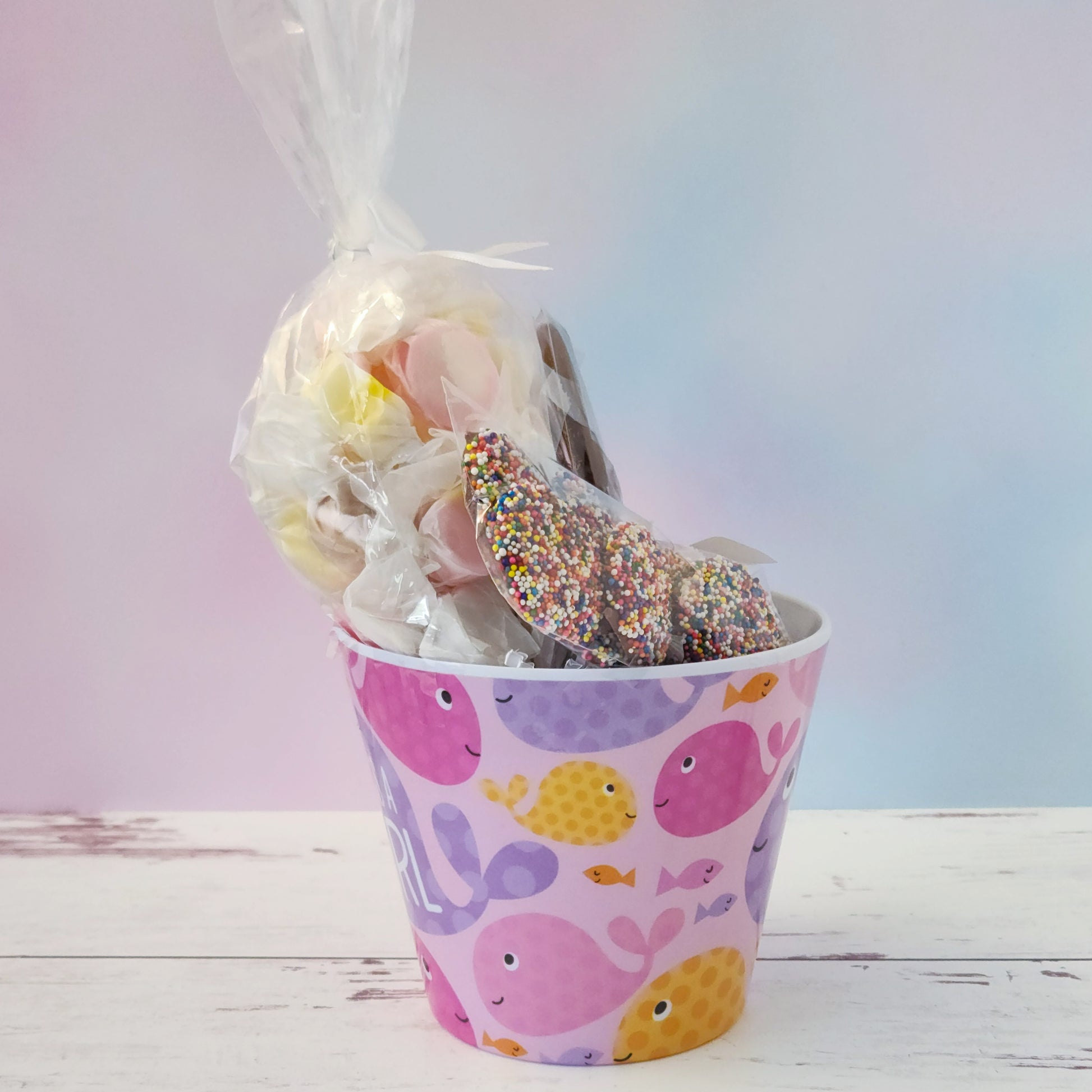 Our "It's a Girl" Baby Basket is a perfect gift for baby showers, new parents, or proud grandparents. Each baby-themed container is filled with a delightful mix of candy favorites including:
8 ounces of soft, chewy salt water taffy in an assortment of classic flavors, milk chocolate nonpareils, and a handmade milk chocolate "It's a Girl" lollipop, all wrapped up and ready to gift.