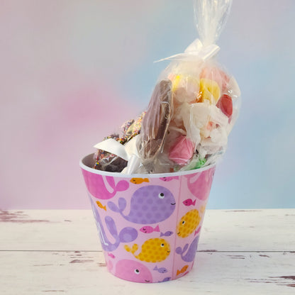 Our "It's a Girl" Baby Basket is a perfect gift for baby showers, new parents, or proud grandparents. Each baby-themed container is filled with a delightful mix of candy favorites including:
8 ounces of soft, chewy salt water taffy in an assortment of classic flavors, milk chocolate nonpareils, and a handmade milk chocolate "It's a Girl" lollipop, all wrapped up and ready to gift.