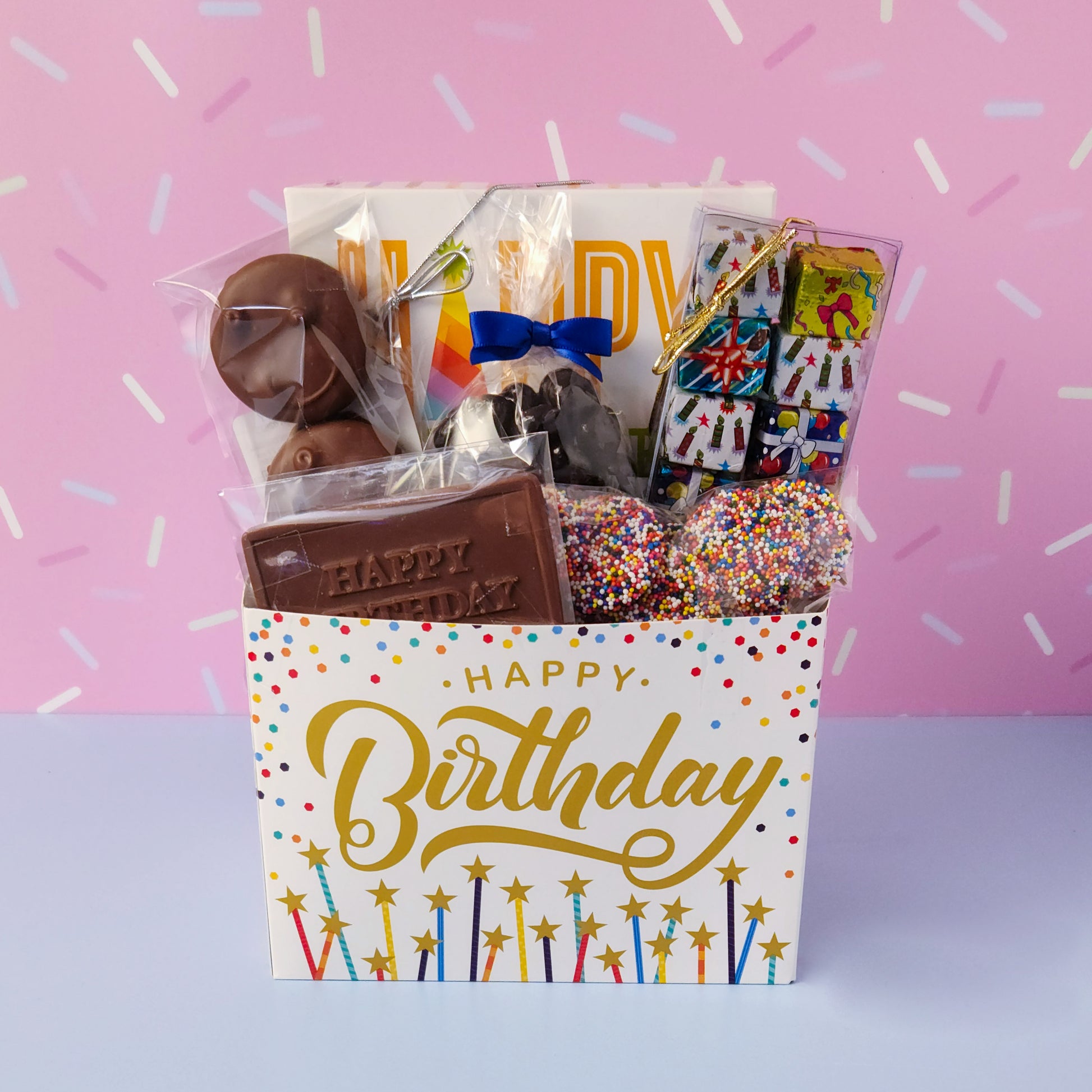 Make birthdays extra special with our Birthday Gift Basket, a delightful assortment of handcrafted chocolates that’s sure to bring a smile to any chocolate lover’s face! Packed with a delicious mix of milk and dark chocolate treats. 
16-Piece Milk and Dark Chocolate Assortment, Milk Chocolate "Happy Birthday" Card, Milk Chocolate Covered Oreos, Milk Chocolate Nonpareils & Foiled Presents, and Dark Chocolate Covered Cranberries all overwrapped and tied with a bow, this basket is ready to gift.