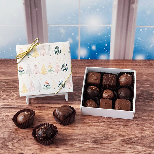 Box of chocolates on a wooden surface with a decorative box in the background
