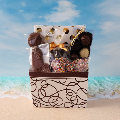 Swirl Cape Cod themed gift basket
Filled with
16-Piece Milk &amp; Dark Chocolate Popular Assortment, Milk Chocolate Lighthouse, Milk Chocolate Covered Oreos, Milk Chocolate Nonpareils, 
Dark Chocolate Covered Cranberries and a chocolate Shell Sampler (10 Pieces).
Overwrapped and tied with a beautiful bow perfect for gifting.