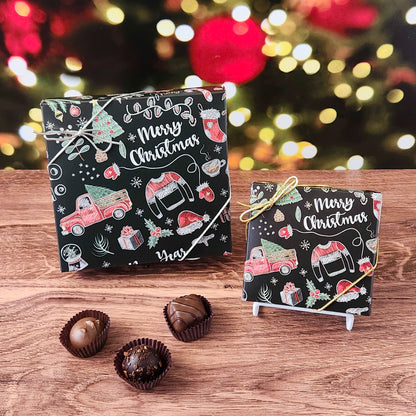 Two small Christmas-themed boxes with candy on a wooden surface, blurred festive lights in the background.