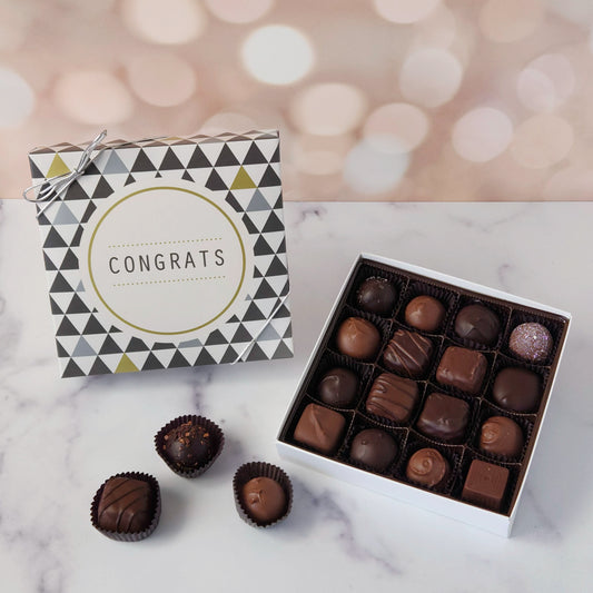 Big wins deserve big flavor! Our Congrats Chocolate Box is the ultimate way to say “You did it!” in the most delicious way possible. This 16-piece assortment of milk and dark chocolates comes packed in a festive box with CONGRATS boldly printed on the lid—making it the perfect gift for graduations, new jobs, retirements, promotions, or any milestone worth celebrating.  Inside, you'll find a mix of creams, caramels, melt-aways, and truffles.