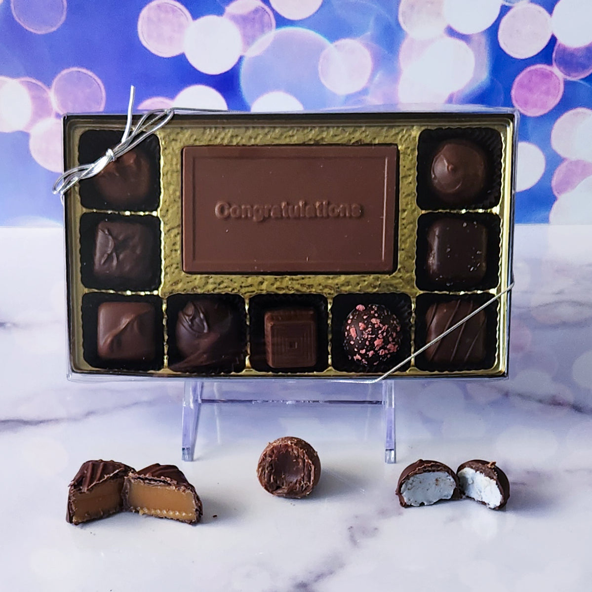  Celebrate their big achievement with our 9-piece Congratulations Candy Box! Inside, a beautifully crafted milk chocolate card that says "Congratulations" is surrounded by an irresistible assortment of milk and dark chocolate soft center creams, rich caramels, and indulgent truffles. It's the perfect way to sweeten their success and share in their joy! 