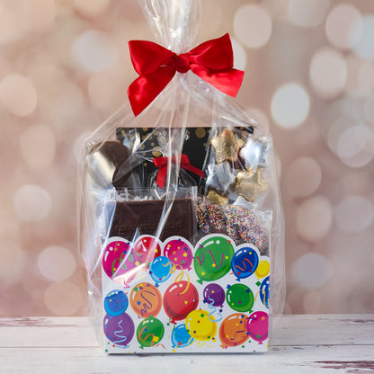 Make life’s big moments even sweeter with our Celebrate Gift Basket!
Inside, you’ll find a mix of gold and silver foiled milk chocolate stars, two chocolate-covered Oreo cookies, and classic milk chocolate nonpareils. A milk chocolate card that says “Congratulations”, dark chocolate-covered cranberries and a luxurious 16-piece assortment of creams, caramels, meltaways, and truffles. All overwrapped with a bow and ready for gifting!