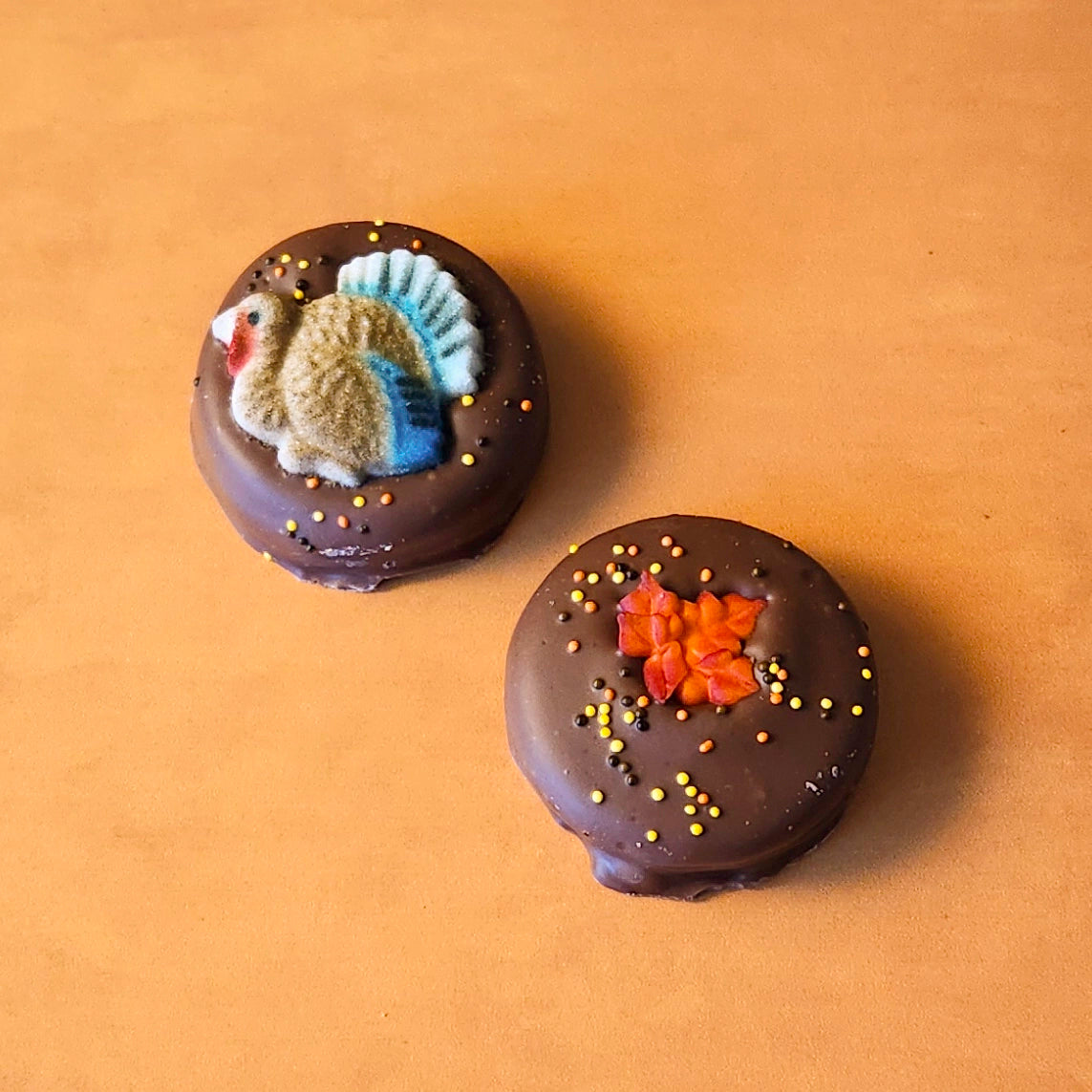 Thanksgiving Themed Chocolate Covered Oreos –  Each pack includes two decadent chocolate-covered Oreos, perfectly decorated for the season – one topped with a charming sugared turkey and the other with a vibrant sugared leaf. 