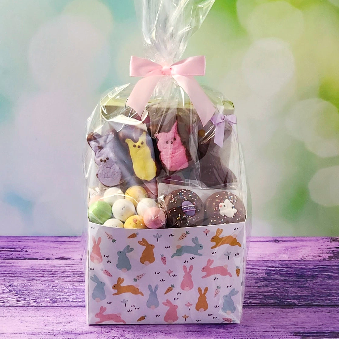 Gift basket with Easter-themed chocolates and candies on a wooden surface