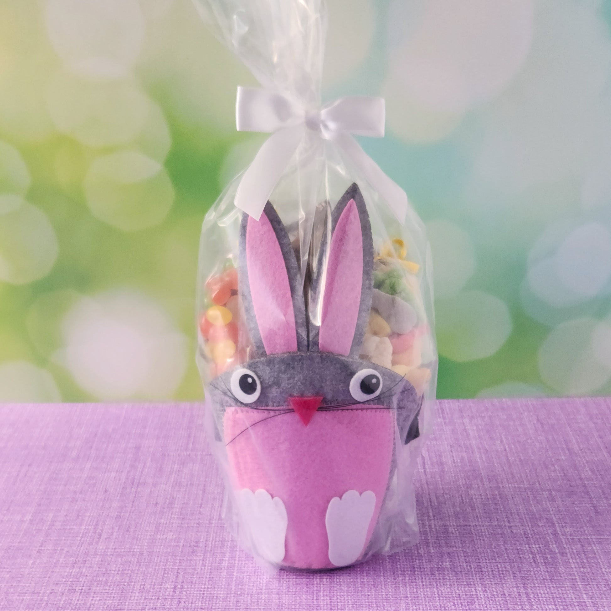 This adorable felt bunny-shaped basket is filled with a delicious assortment of Chocolate-Dipped Marshmallow Peeps, fruity Jelly Beans, Sanded Gummi Bunnies, and a Chocolate Bunny Favor. Wrapped in overwrap and finished with a beautiful bow