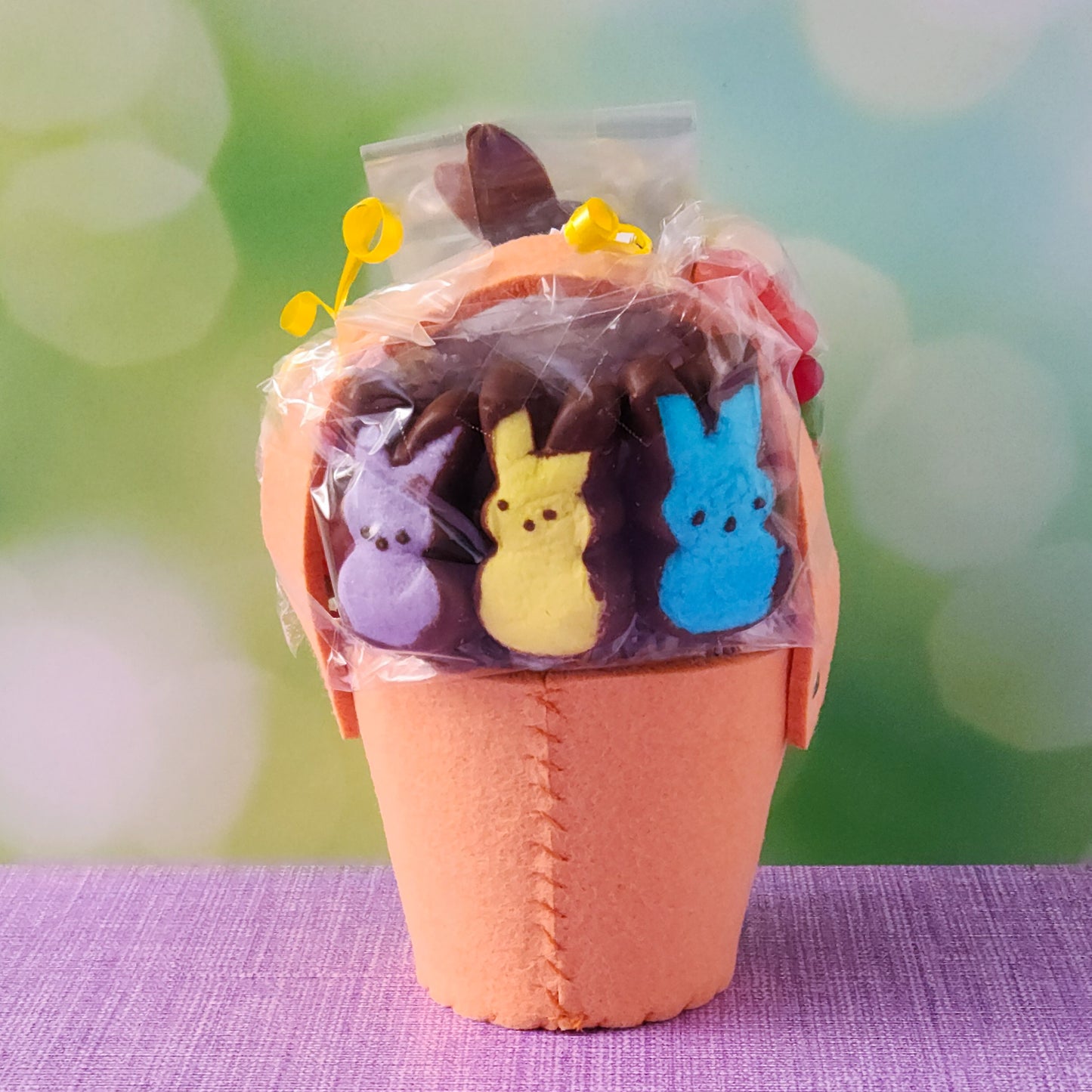 The basket base is an adorable felt fox, filled with an irresistible assortment of Chocolate-Dipped Marshmallow Peeps, fruity Jelly Beans, Sanded Gummi Bunnies, and a delicious Chocolate Bunny Favor. Finished with overwrap and a festive bow, this basket is ready to gift