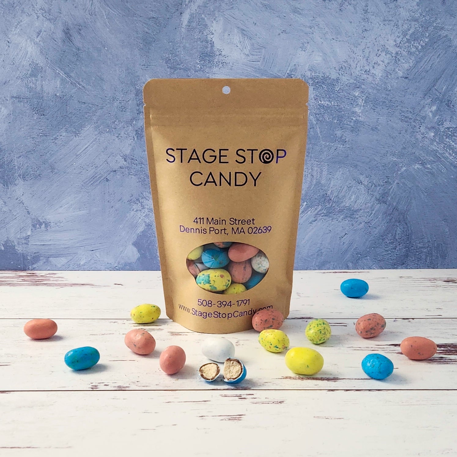 Stage Stop Candy packaging with assorted candies on a wooden surface and purple background