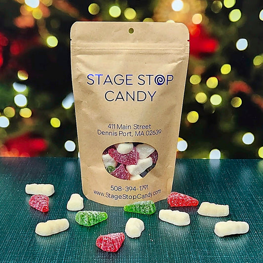 Gummi Snowmen and Trees with Snow in a kraft bag, with sugar-coated red and green trees and white snowmen on a teal table