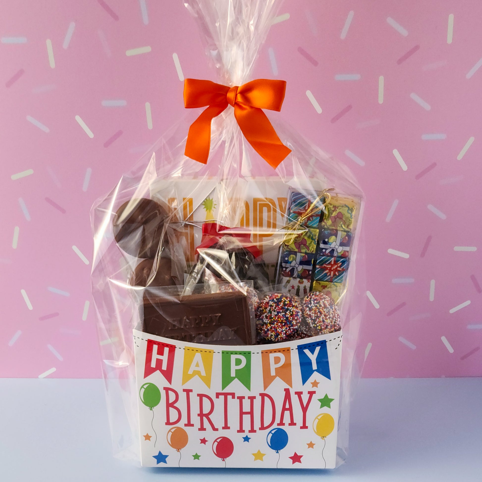 Make birthdays extra special with our Birthday Gift Basket, a delightful assortment of handcrafted chocolates that’s sure to bring a smile to any chocolate lover’s face! Packed with a delicious mix of milk and dark chocolate treats. 
16-Piece Milk and Dark Chocolate Assortment, Milk Chocolate "Happy Birthday" Card, Milk Chocolate Covered Oreos, Milk Chocolate Nonpareils & Foiled Presents, and Dark Chocolate Covered Cranberries all overwrapped and tied with a bow, this basket is ready to gift.