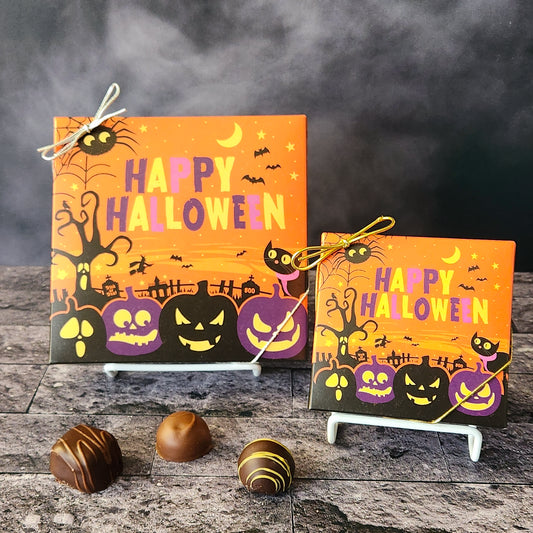 An assortment of our most popular milk and dark chocolate creams, caramels, melt-aways, and truffles all packed inside a box with the words Happy Halloween printed on the cover.