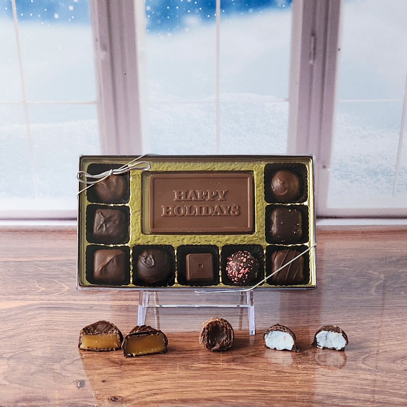 Celebrate the season with our 9-piece Happy Holidays Candy Box! Inside, a beautifully crafted milk chocolate card that says "Happy Holidays" is surrounded by a delectable assortment of creamy milk and dark chocolate soft center creams, rich truffles, and delightful caramels. It's the perfect way to spread holiday joy and sweeten the festivities!