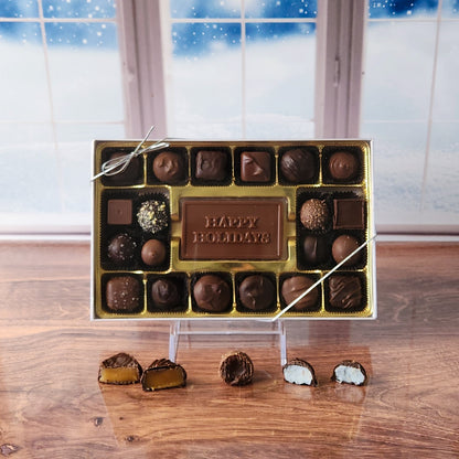  Make the season bright with our 20-piece Happy Holidays Candy Box! Inside, a beautifully crafted milk chocolate card that says "Happy Holidays" is surrounded by an irresistible assortment of smooth milk and dark chocolate soft center creams, decadent truffles, and rich caramels. It's the perfect way to share festive joy and delicious treats with loved ones!