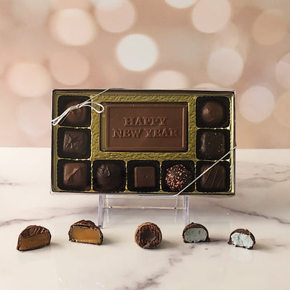 Celebrate the new year with our 9-piece Happy New Year Candy Box! Inside, a beautifully crafted milk chocolate card that says "Happy New Year" is surrounded by a delectable assortment of creamy milk and dark chocolate soft center creams, indulgent truffles, and rich caramels. It's the perfect way to share sweet moments and welcome the new year with joy!