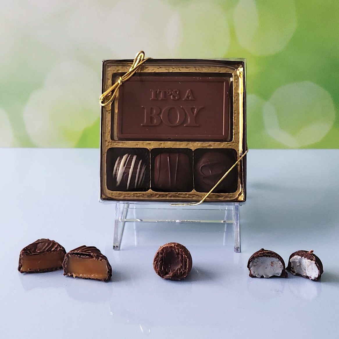 Celebrate the new arrival with our 3-piece It's a Boy Candy Box! Inside, a beautifully crafted milk chocolate card that says "It's a Boy" is paired with a smooth soft center cream, an indulgent truffle, and a delicious caramel. It's the perfect small treat to share the joy of this special occasion!