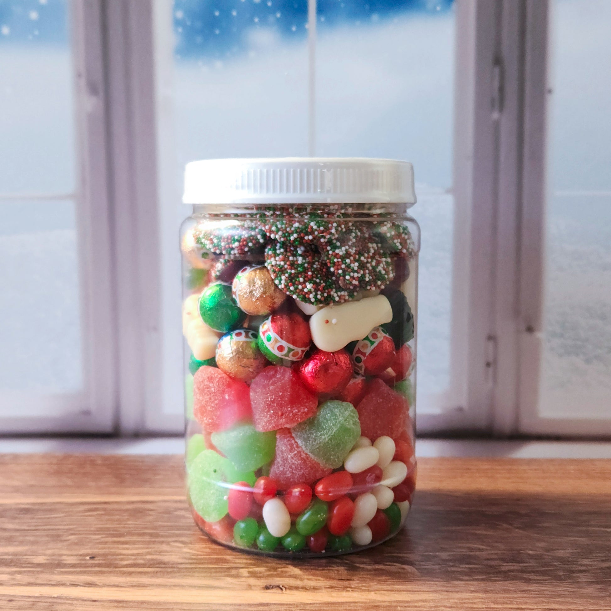 Our Christmas Jarcuterie jars are a festive treat and the perfect gift for spreading holiday cheer! Each jar is packed with delicious layers, beginning with a bed of red, green, and white jelly beans, followed by a colorful layer of jolly Jingle Bell jells. Next come our multi-colored milk chocolate “ornaments,” adding a creamy touch of chocolate to the mix, followed by a fun layer of snowman and tree gummies. To finish, we’ve topped each jar with delightful milk chocolate Christmas nonpareils.