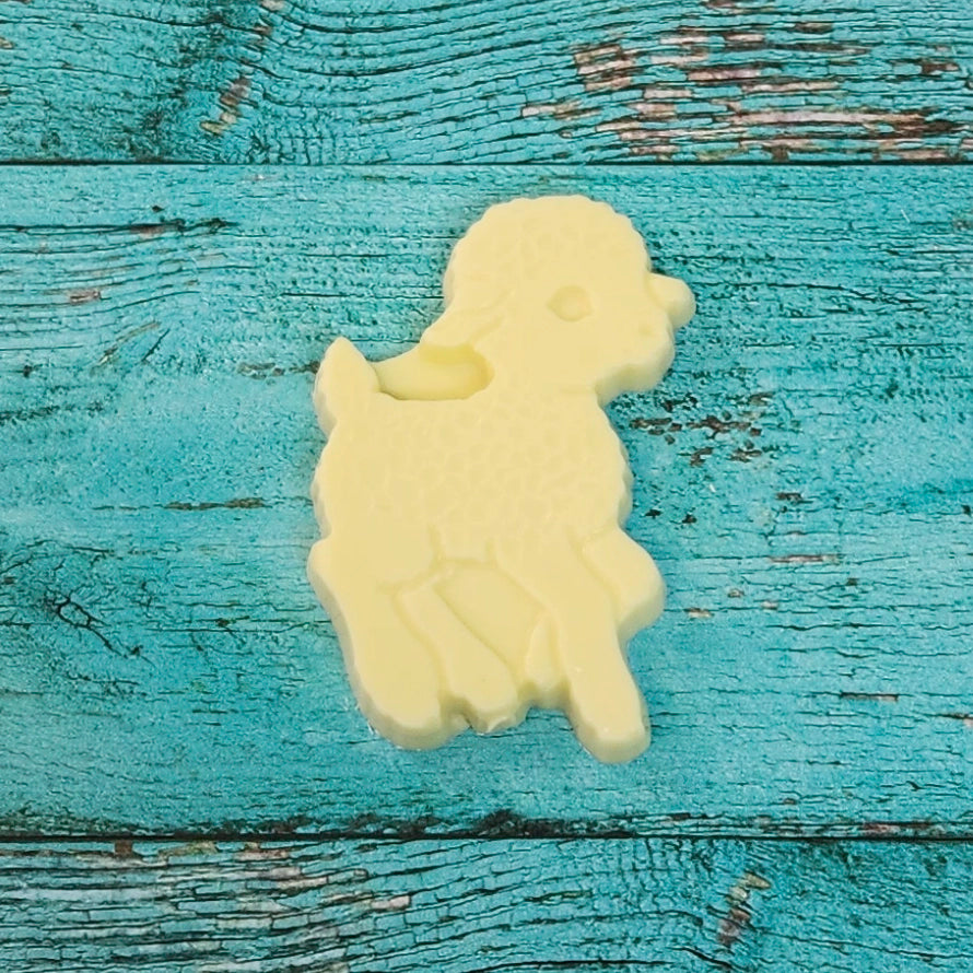 White lamb-shaped chocolate on a blue wooden surface