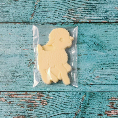 Lamb-shaped white chocolate in clear packaging on a blue wooden surface