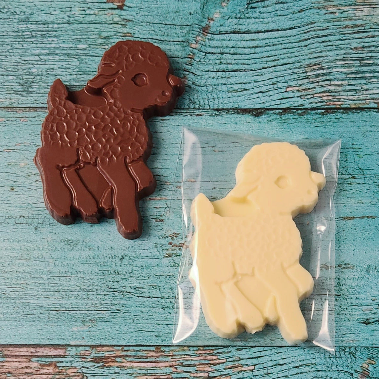 Chocolate and white lamb-shaped candies on a wooden surface