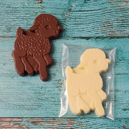 Chocolate and white lamb-shaped candies on a wooden surface