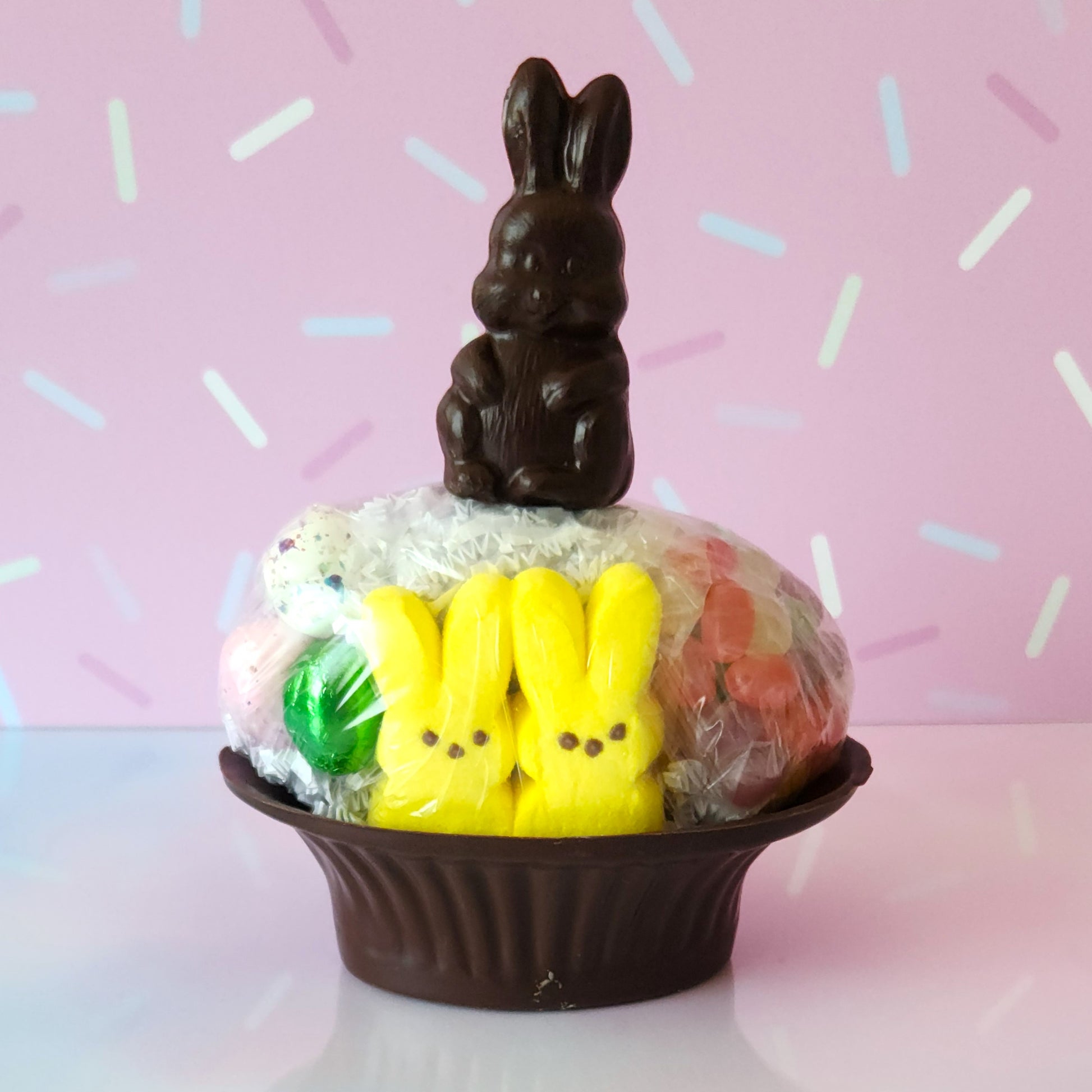 Our Medium Chocolate Basket is made of Dark chocolate. We then fill it with fruit flavored jelly beans, soft marshmallow Peeps, chocolate foiled eggs, speckled malt eggs, and a chocolate covered Oreo. To finish the look a chocolate Easter Bunny pop stands on top.
***Due to its fragile nature this item is only available for in-store pick-up. It can not be shipped***