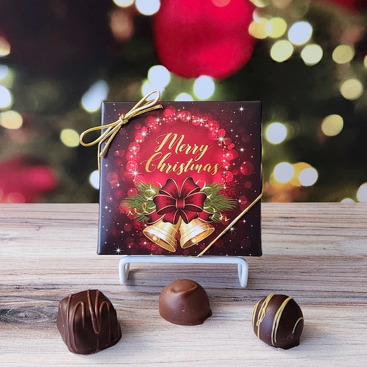 An assortment of our most popular milk and dark chocolate creams, caramels, melt-aways, and truffles all packed inside a box with the saying "Merry Christmas" written above some festive holiday bells printed on the cover.