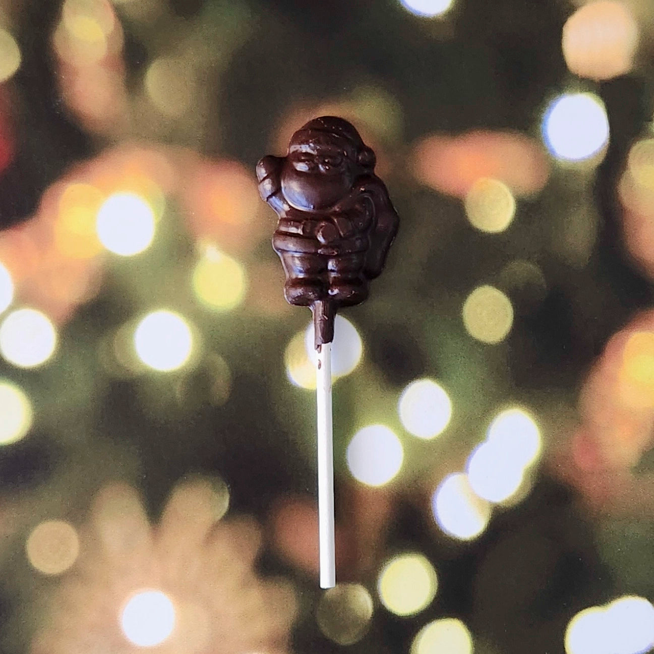 Spread a little extra holiday cheer with our Dark chocolate Mini Santa Waving Lollipop! This bite-sized chocolate pop, crafted in the shape of a waving Santa, is the perfect festive touch for any stocking, gift bag, or holiday gathering