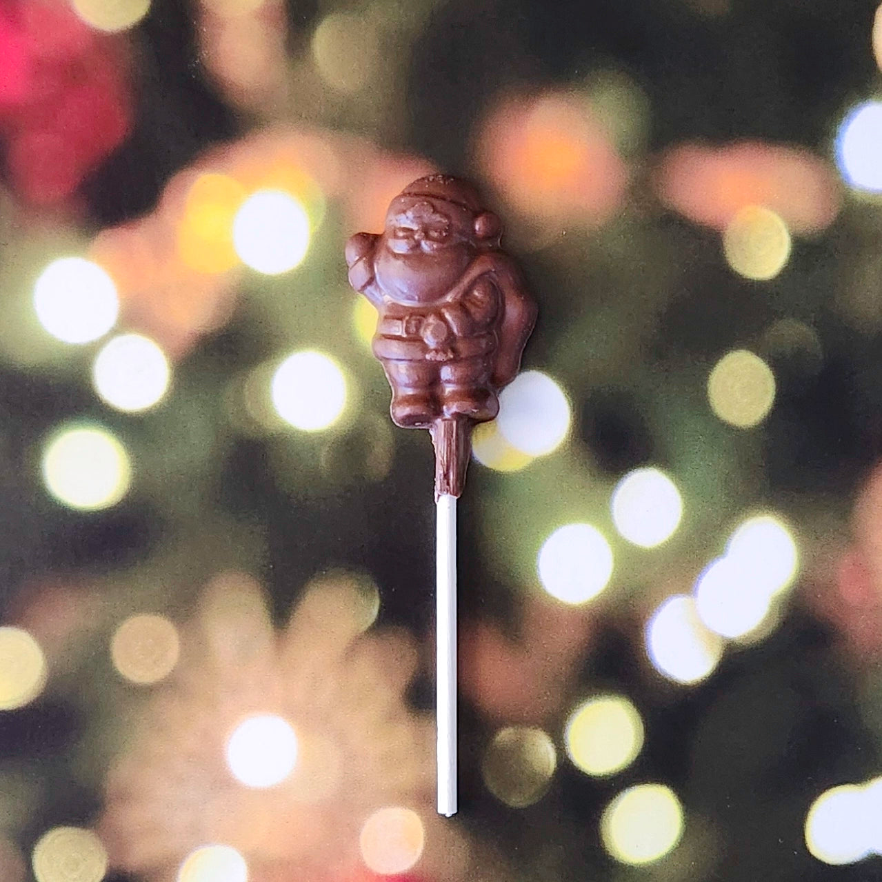 Spread a little extra holiday cheer with our Milk Chocolate Mini Santa Waving Lollipop! This bite-sized chocolate pop, crafted in the shape of a waving Santa, is the perfect festive touch for any stocking, gift bag, or holiday gathering