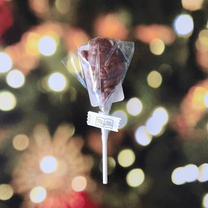 Spread a little extra holiday cheer with our Mini Santa Waving Lollipop! This bite-sized chocolate pop, crafted in the shape of a waving Santa, is the perfect festive touch for any stocking, gift bag, or holiday gathering